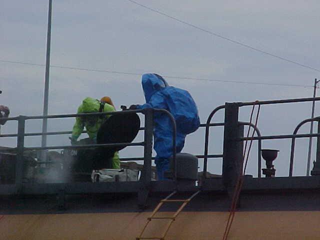 Two fire fighters learning how to diffuse a dangerous rail car.